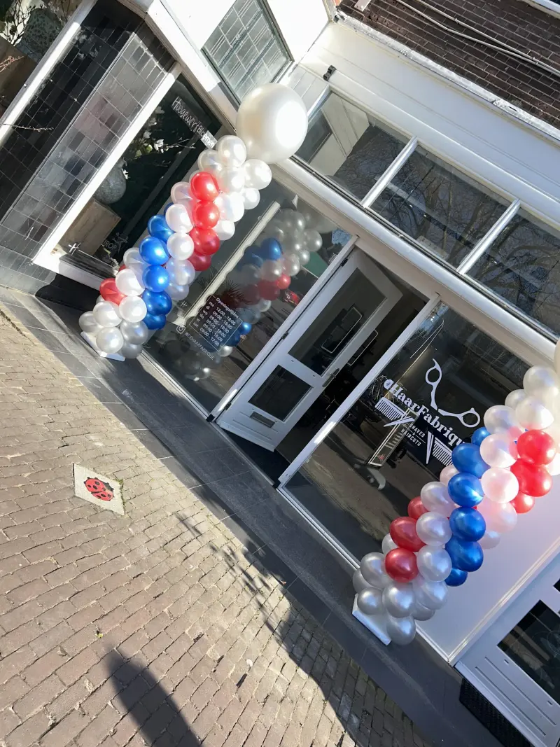 De ingang bij de opening, versierd met ballonnen in rood, wit en blauw